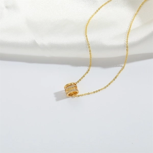 Elegant gold necklace with a zircon-encrusted cylindrical ring pendant on silk