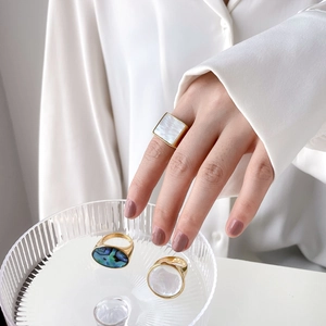 Geometric gold ring set featuring square and oval natural shell and abalone inlays