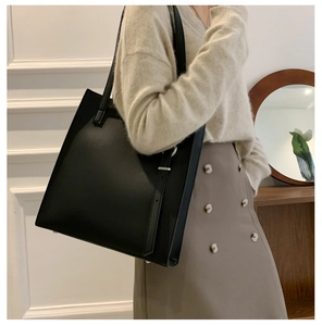 Shoulder view of a black large capacity tote bag styled for casual commuting