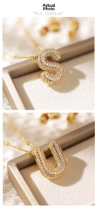 Detailed view of gold-plated S and U letter pendants with sparkling pavé zircons