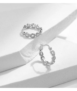 Gros plan sur les boucles d'oreilles Mobius en argent S925 serties de zircons brillants