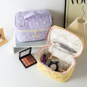 Detail of quilted plaid cosmetic bags with bow embroidery and internal mesh pocket