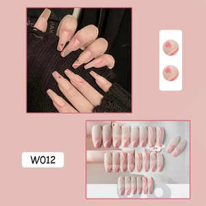 Detail view of long trapezoid press-on nails with nude pink waves and red hearts