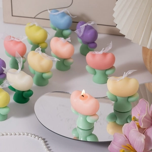 Detailed view of colorful tulip-shaped candles with white ribbon decor and candle wick