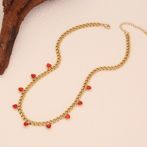 Detailed view of gold Cuban chain necklace with eight red heart-shaped crystal pendants