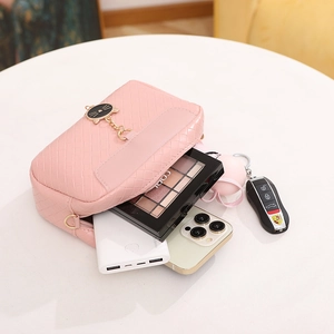 Pink woven shell-shaped crossbody bag with gold cat charm and daily makeup storage