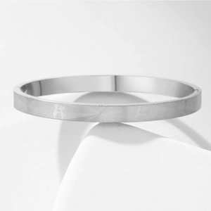 Dettaglio macro del bracciale in acciaio al titanio argento con fine trama a onde radiali