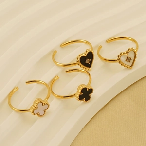 Detail of 18k gold plated clover and heart open rings with shell inlays on wave surface