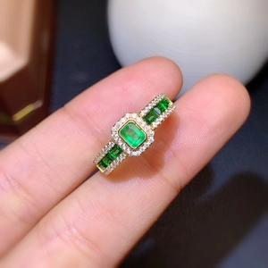 Luxury emerald cut green gemstone ring with micro-pave diamonds in gold plating