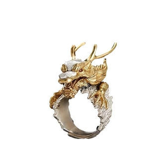 Vintage gold and silver dragon ring with red eyes and textured relief on white background