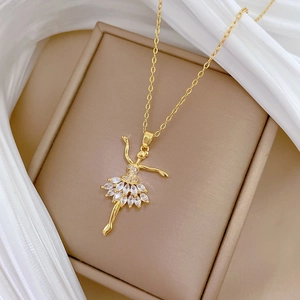 Collana con pendente ballerina dorata con gonna di cristalli su portagioie beige