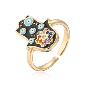 Macro shot of gold-plated Hamsa ring with blue evil eye pattern and colorful zircons