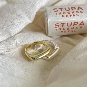 Detailed view of minimalist square-round rings in gold and silver mirror-finish metal