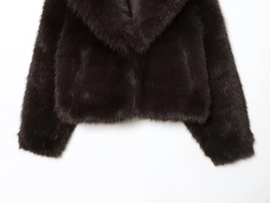 Détail de la veste en fausse fourrure marron foncé montrant la texture du col