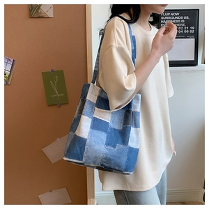 Detailed close-up of blue patchwork denim tote bag with stylish stitched pattern