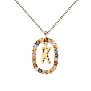 Macro shot of gold necklace pendant with colorful zircon stones and central letter K