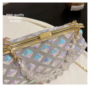 Close-up of sparkling sequin evening bag featuring gold metal frame and beaded handle