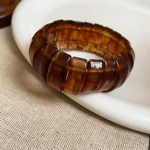 Retro amber resin elastic bracelet with tortoise shell pattern on ceramic dish