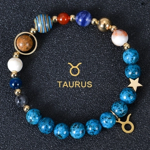Macro shot of Taurus zodiac bracelet with 8mm blue natural stones and golden star charms