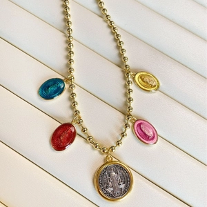 Gold beaded necklace with colorful Virgin Mary pendants and Saint Benedict medal