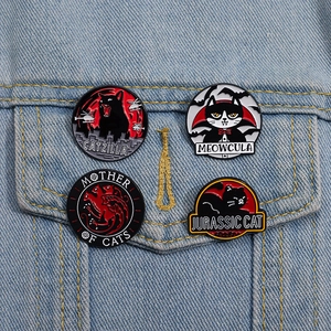 Detail view of four parody black cat enamel pins pinned on a light blue denim jacket pocket