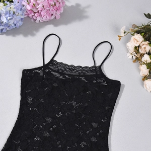 Primer plano del encaje floral negro en un vestido de tirantes ajustado y elegante