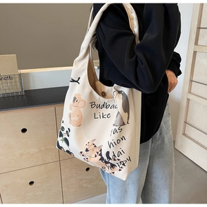 Detail of canvas tote bag showing cartoon animal print and secure magnetic closure