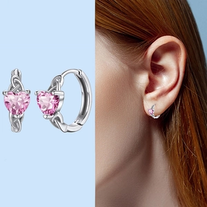 Detail of pink heart-shaped crystal huggie earrings with silver woven band design
