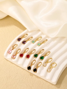 Close-up of teardrop pear-cut zircon huggie earrings in seven assorted colors