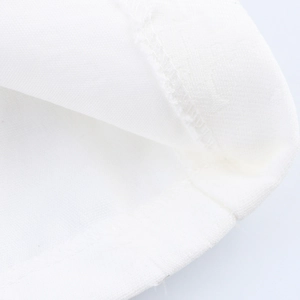 Dettaglio del tessuto bianco con frange e doppie cuciture sul cappotto oversize donna