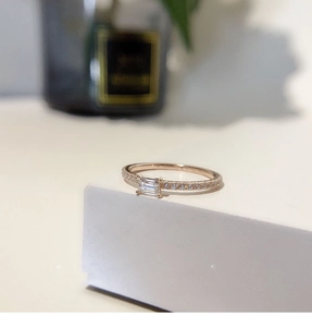 Macro view of emerald-cut square faux diamond ring in rose gold finish with paved band