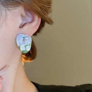 Close-up of French vintage enamel flower earrings with pearls and colorful zircons