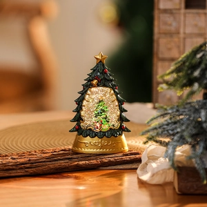Macro shot of a Christmas tree snow globe on a wood bark stand with festive glitter