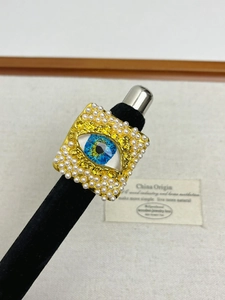 Macro detail of vintage evil eye square ring with gold texture and pearl border
