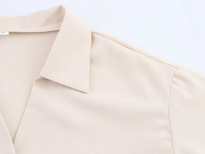 Detailed macro view of beige collared shirt featuring premium textured fabric and neat stitching