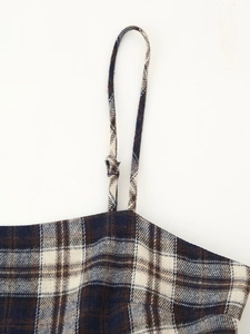 Detailed macro view of the blue and brown plaid fabric texture and shoulder strap sewing