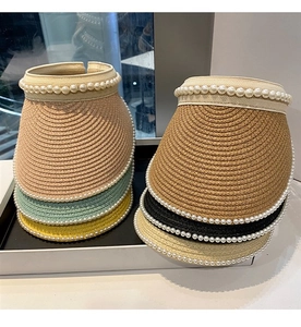 Detail of straw woven sun visors with elegant pearl trim in various vibrant summer colors