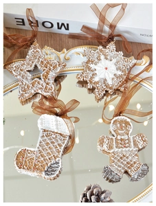 Charming resin gingerbread ornaments in star, snowflake, and sock shapes on a gold tray