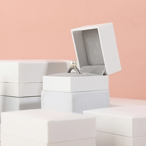 White textured paper jewelry box with grey velvet lining and pearl ring display