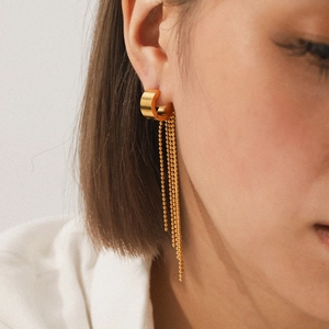 Golden stainless steel hoop earrings with hanging bead chain tassels on model