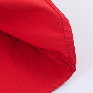 Macro shot of red midi dress fabric showing high-quality stitching and plain texture details