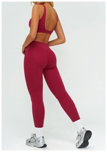Dettaglio dei leggings bordeaux a vita alta e reggiseno sportivo con schiena incrociata