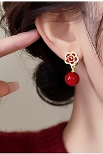 Gros plan de boucles d'oreilles roses rouges avec plaquage or et zircons blancs