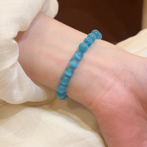 Primer plano de una elegante pulsera de cuentas de ojo de gato azul en la muñeca