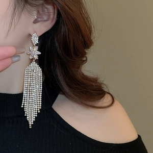 Close-up of sparkling silver floral tassel earrings featuring long rhinestone crystal chains