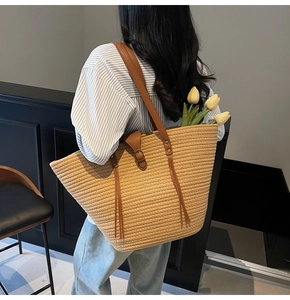 Detail of khaki woven straw tote bag with brown PU leather straps and yellow tulips