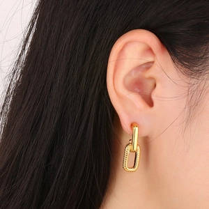 Detail of gold-plated titanium steel C-shaped earrings with irregular checkered texture
