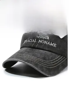 Detailed macro view of embroidered text on a vintage washed grey baseball cap visor