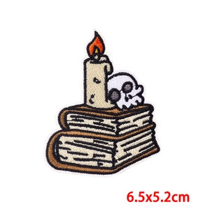 Detailed embroidery patch with skull candle and books design measuring 6.5x5.2cm