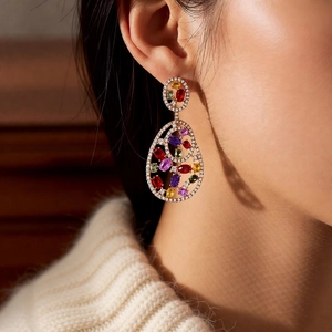 Detail of vintage teardrop earrings with multi-colored gemstones and micro-pave diamonds